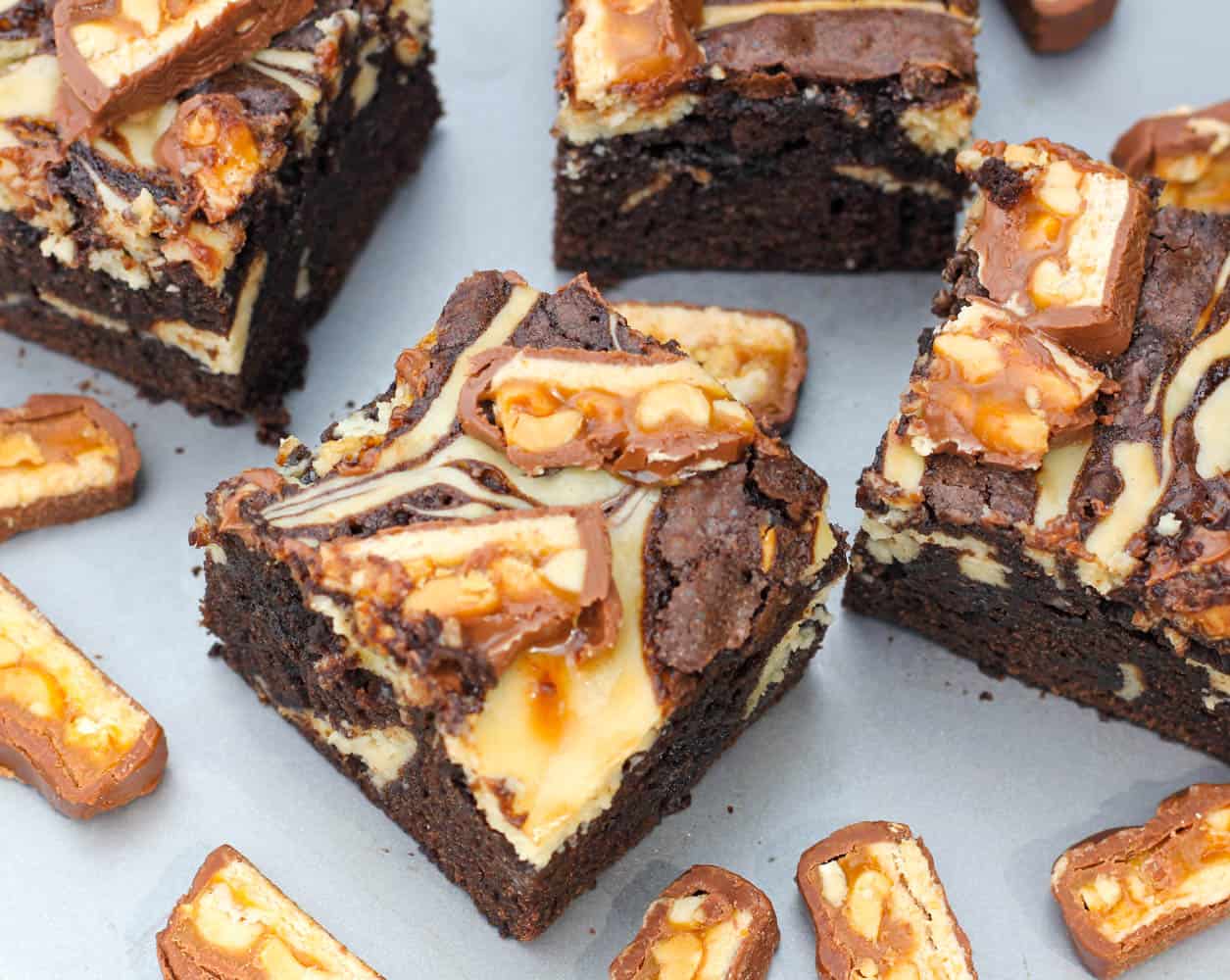 Kahlua Cheesecake Snickers Brownies recipe with candy bars and cream cheese swirl