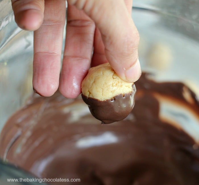 dipping base of Mini Cupcake Golden Oreo Cookie Balls in chocolate