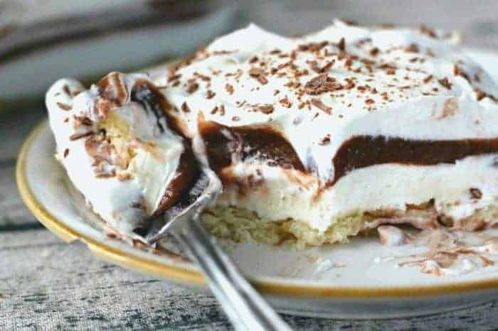 SLICES OF CHOCOLATE DESSERT WITH WHIPPED CREAM AND CREAM CHEESE LAYERS
