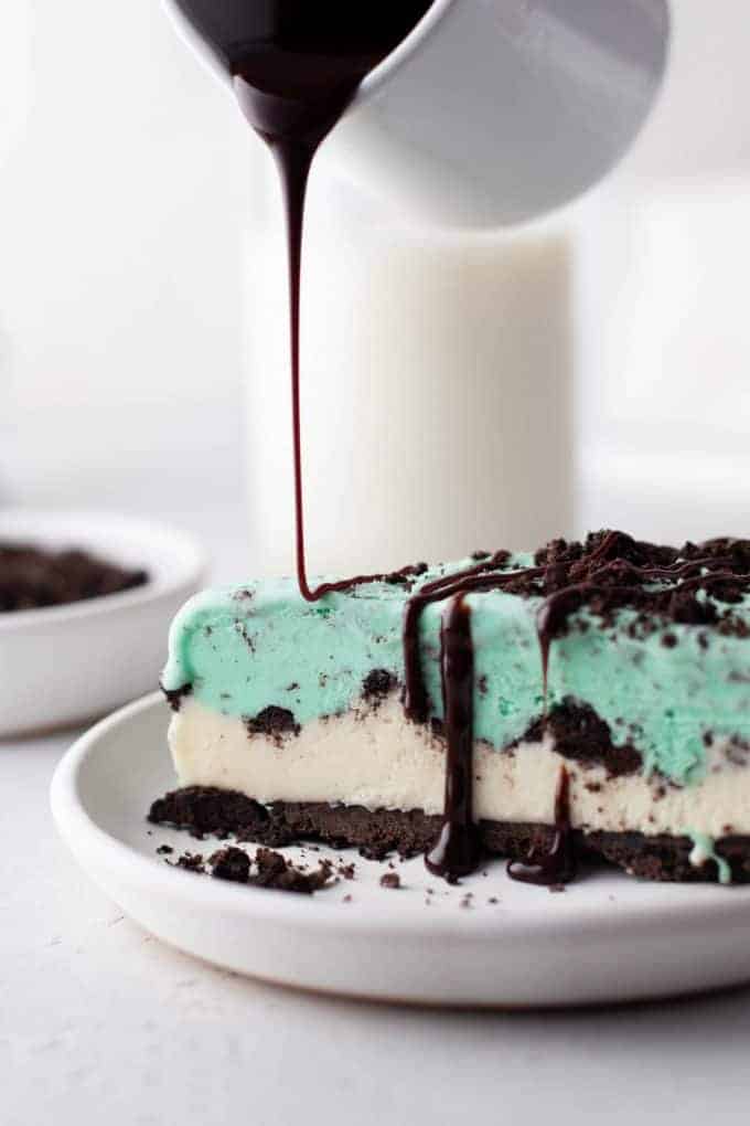 Grasshopper Ice Cream Pie is an insanely delicious (and easy!) dessert with a homemade Oreo crust and layers of vanilla ice cream, Oreo cookies, and mint chip ice cream. Then it gets drizzled with chocolate syrup for maximum chocolate effect