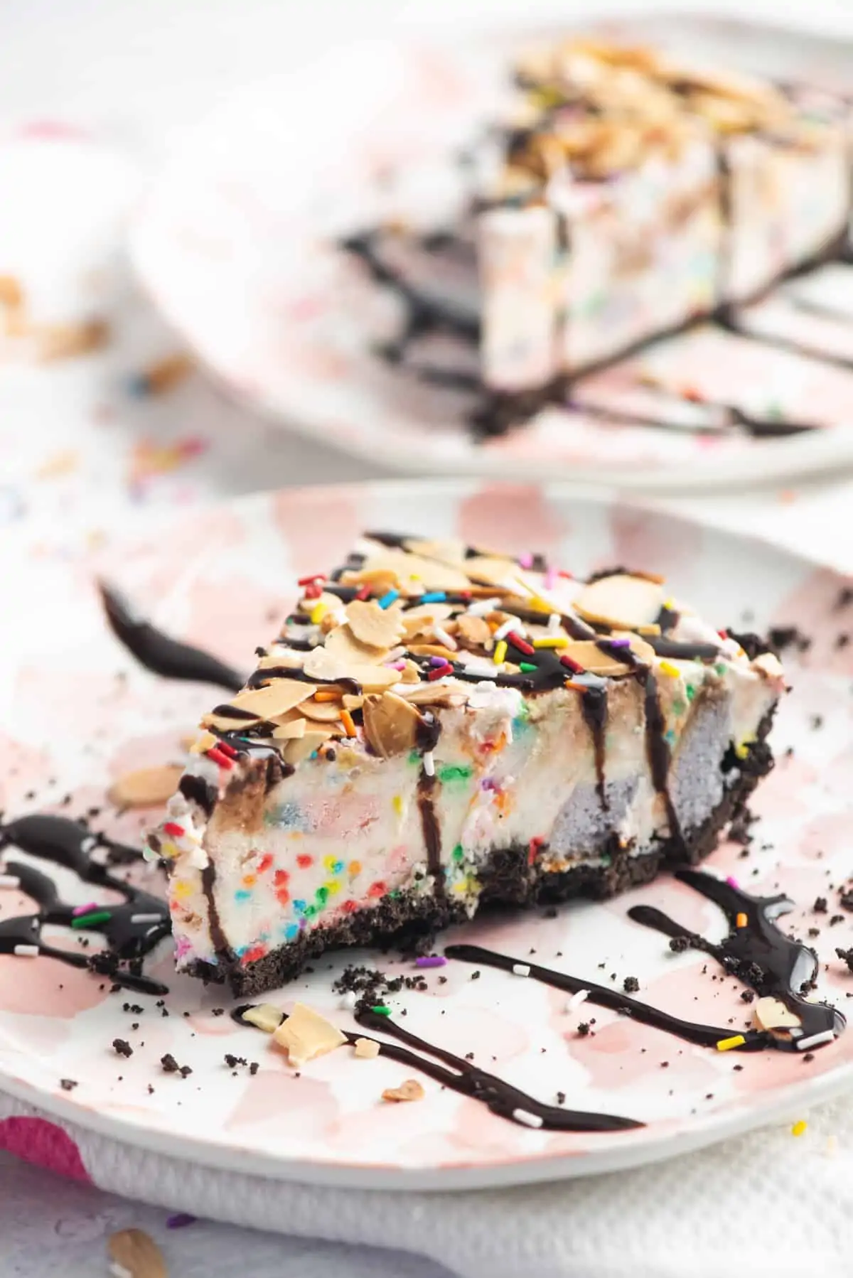 An easy homemade ice cream pie recipe made with a chocolate crust, vanilla ice cream, chunks of cake, chocolate syrup, toasted almonds, and lots of sprinkles. This also makes great birthday party cake, especially for summer. Nothing beats ice cream cake on a hot summer day!