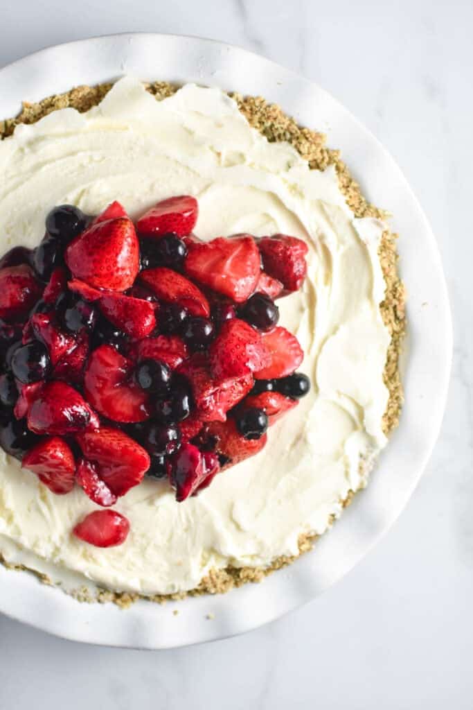 This vanilla ice cream pie is my favorite summer recipe! A wonderful oat and pumpkin seed crust is filled with creamy vanilla ice cream and topped with fresh strawberries and blueberries. This recipe is so easy, and also works for gluten free and dairy free diets. 