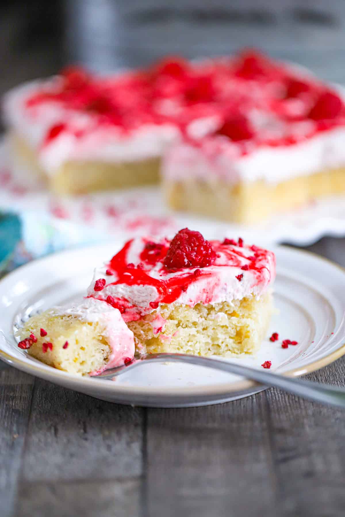 Lemon cake batter being poured into a parchment-lined baking pan