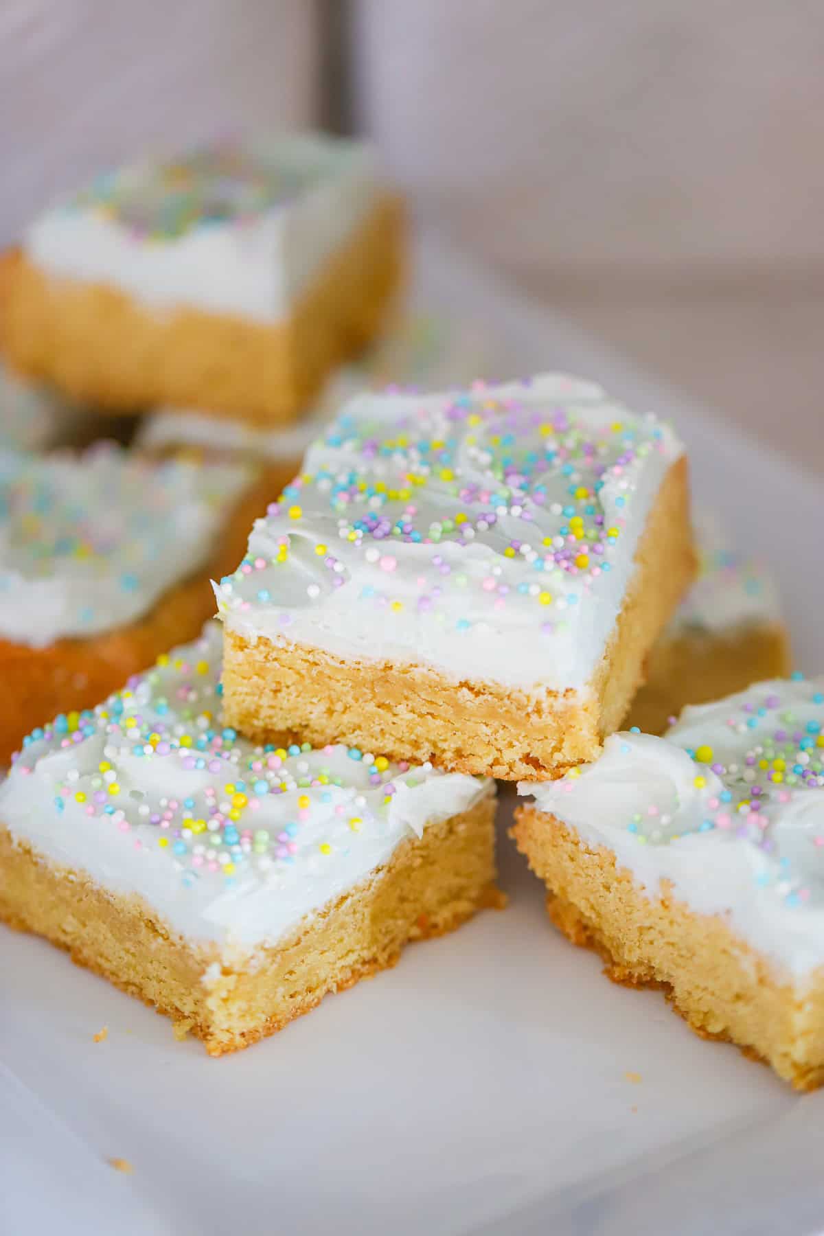 Thick frosted bars stacked showing soft chewy texture with pastel sprinkles