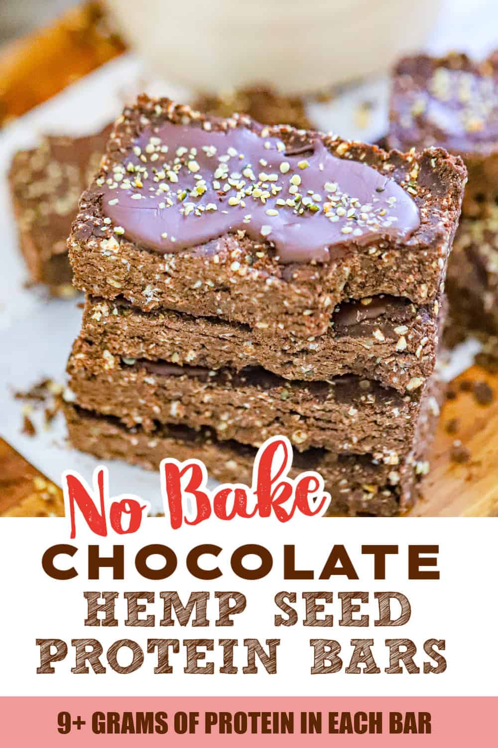 No bake chocolate hemp seed protein bars with chocolate drizzle on a cutting board
