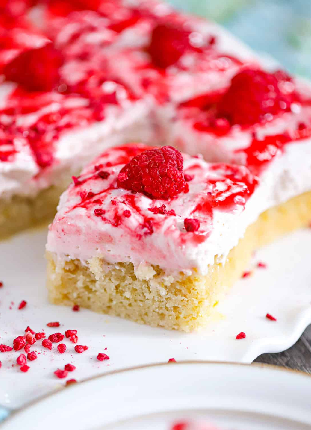 raspberry lemon cream cake bars with fluffy lemon cake and pink raspberry cream layer