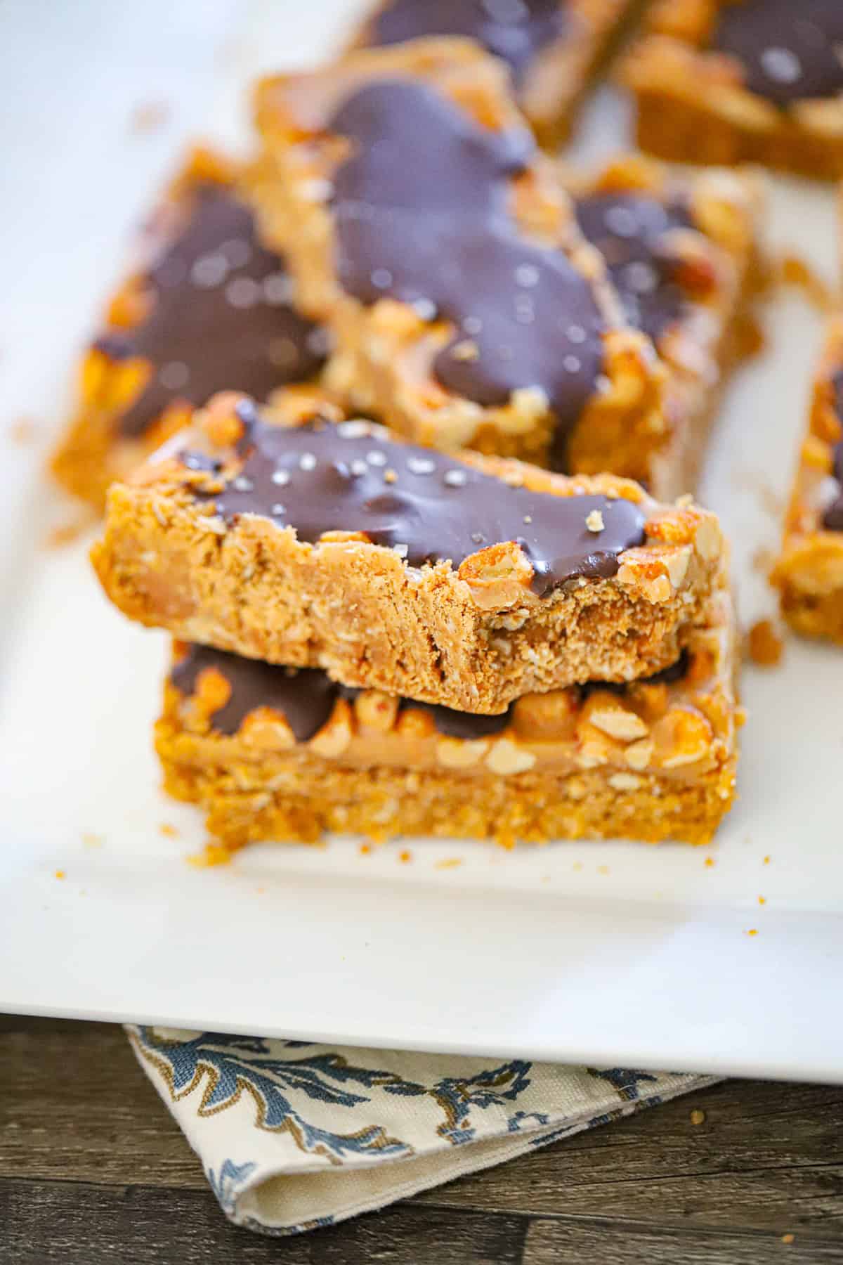 Sliced homemade snickers protein bars on parchment paper showing all three layers