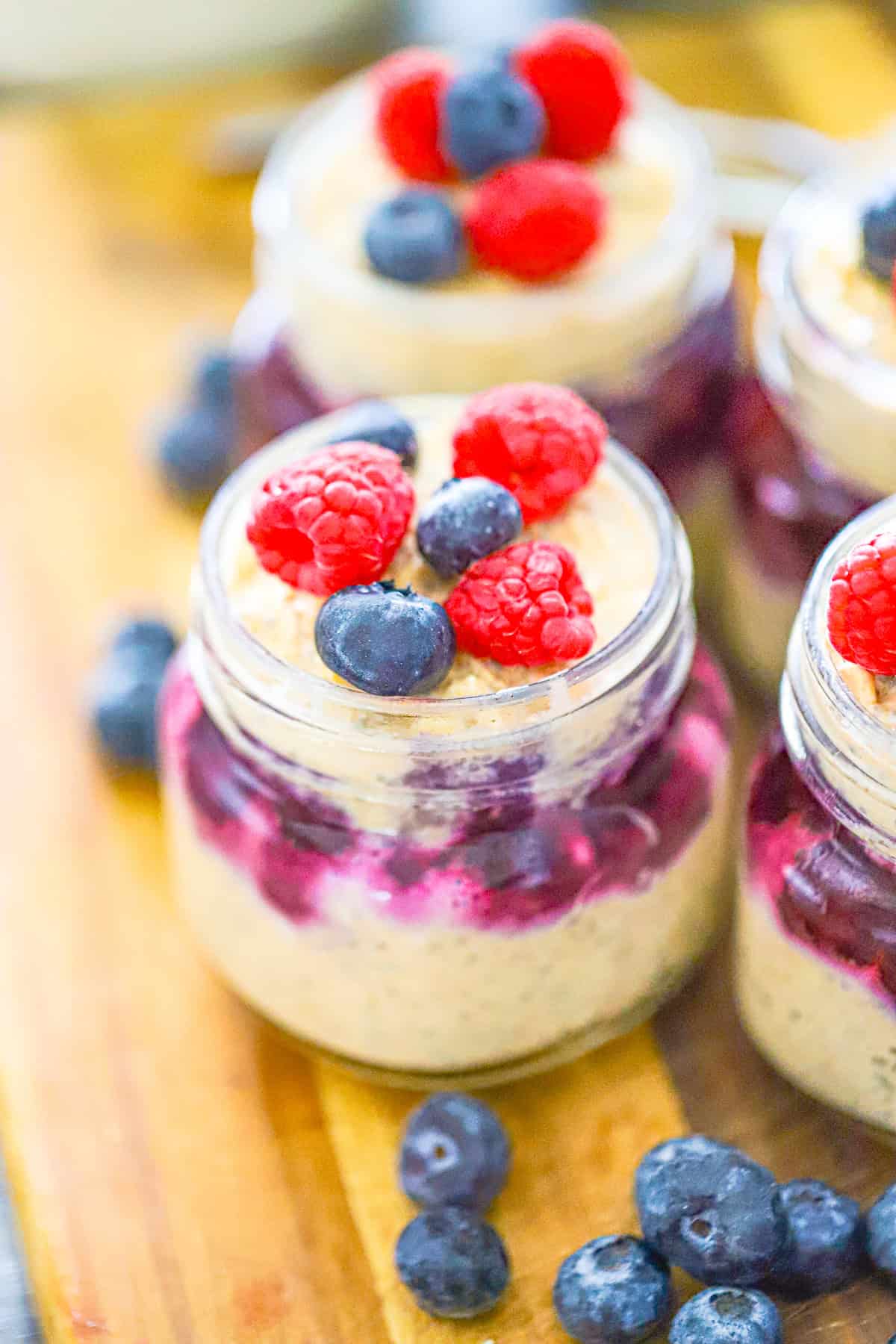 Blueberry protein overnight oats layered with blueberry swirl and fresh berries in a glass jar