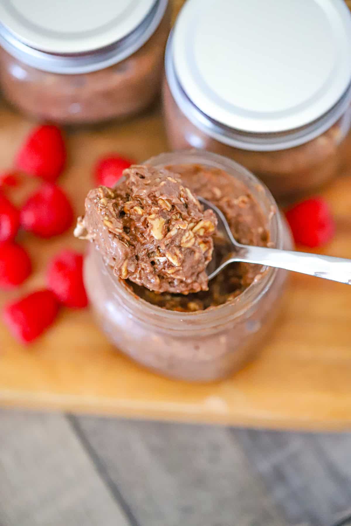Thick chocolatey oats in a jar with walnuts and chocolate drizzle