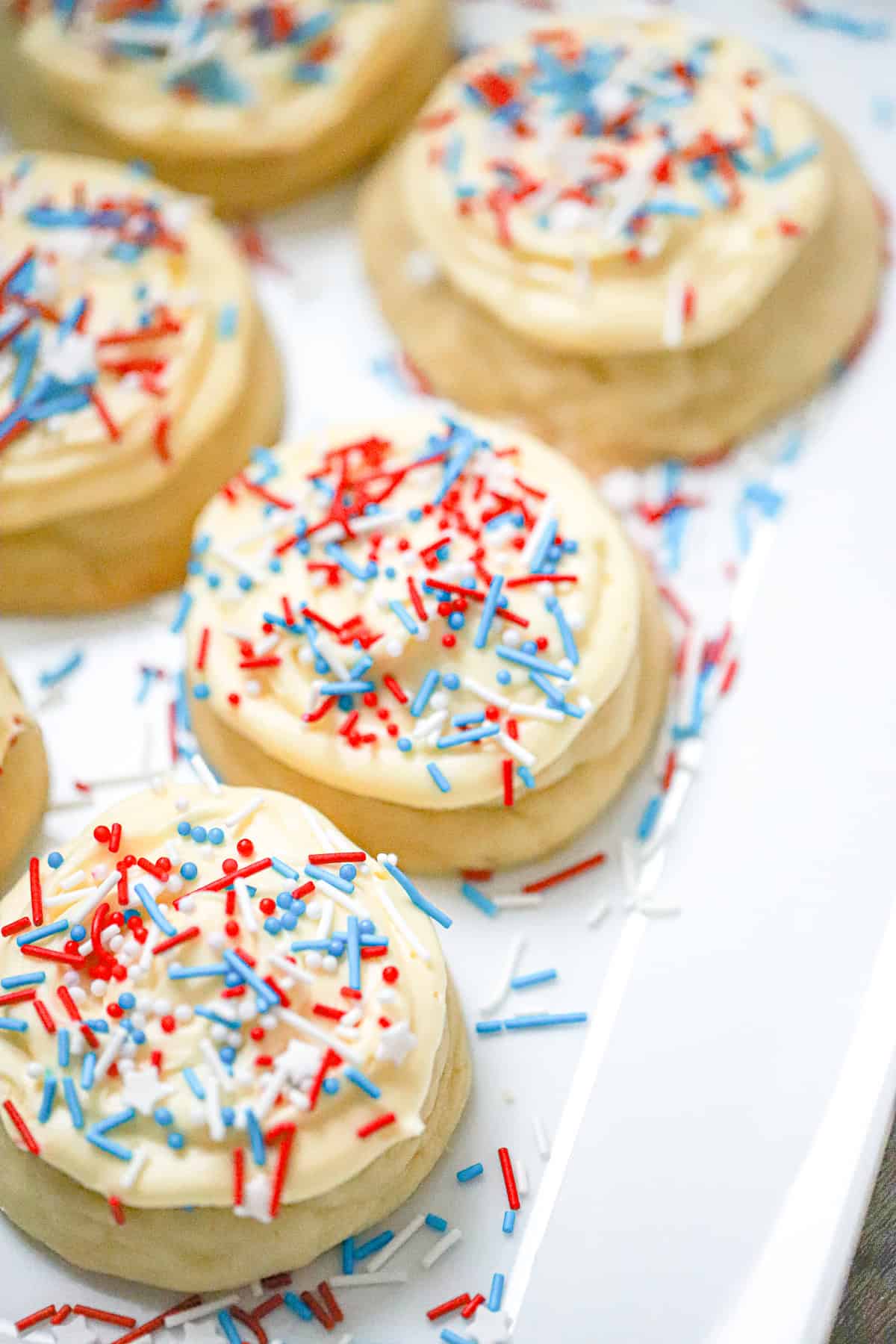 Patriotic Crumbl cookie dough balls on a parchment-lined baking sheet red white and blue cookies
