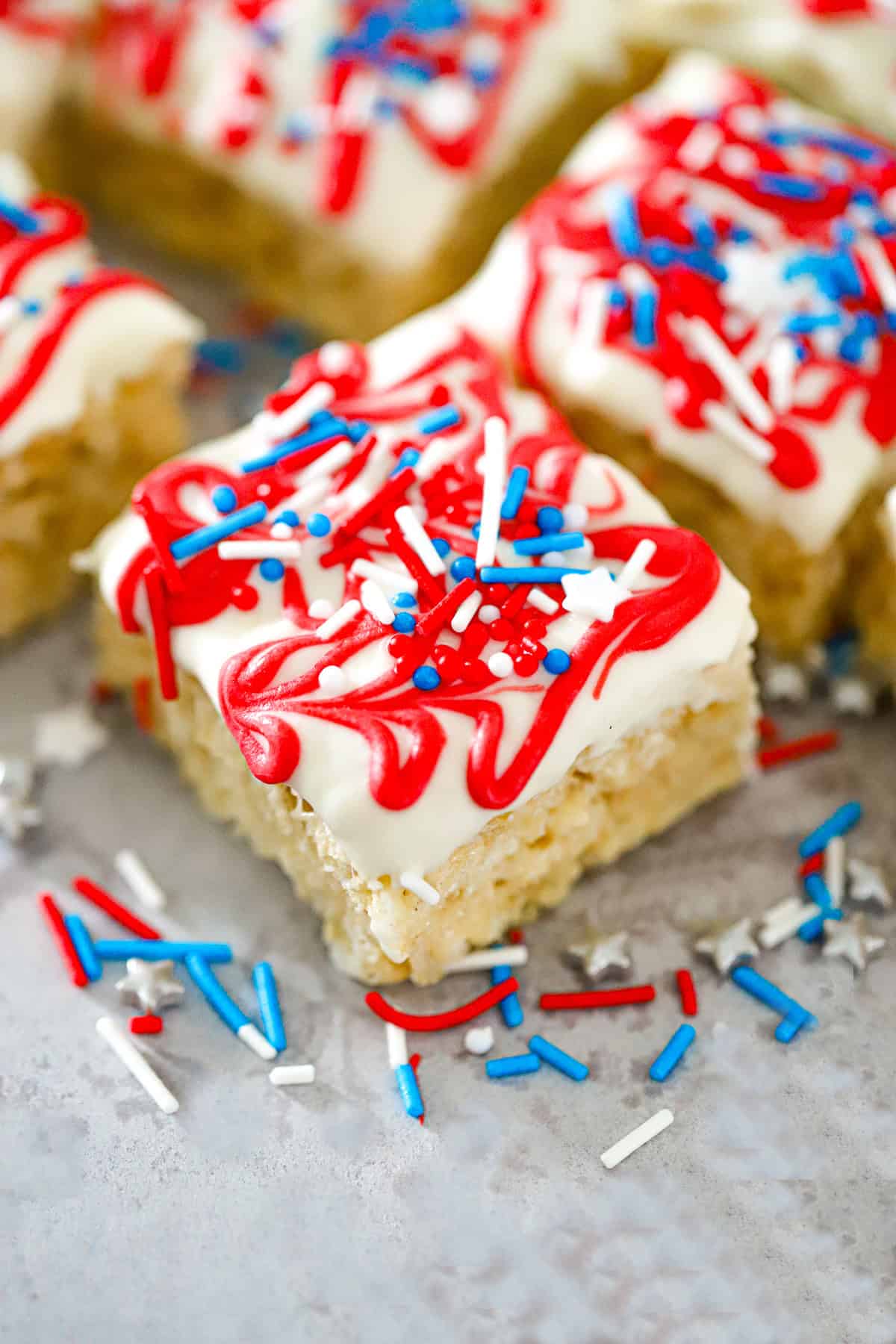 White chocolate dipped squares with red zig-zag drizzle and sprinkles patriotic krispie treats