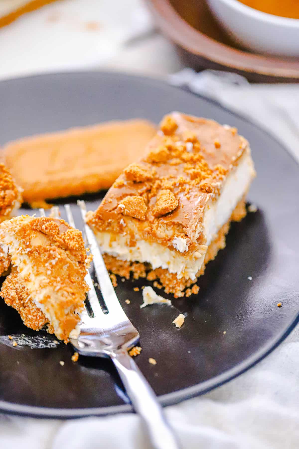 Biscoff protein cheesecake bars stacked on a serving board
