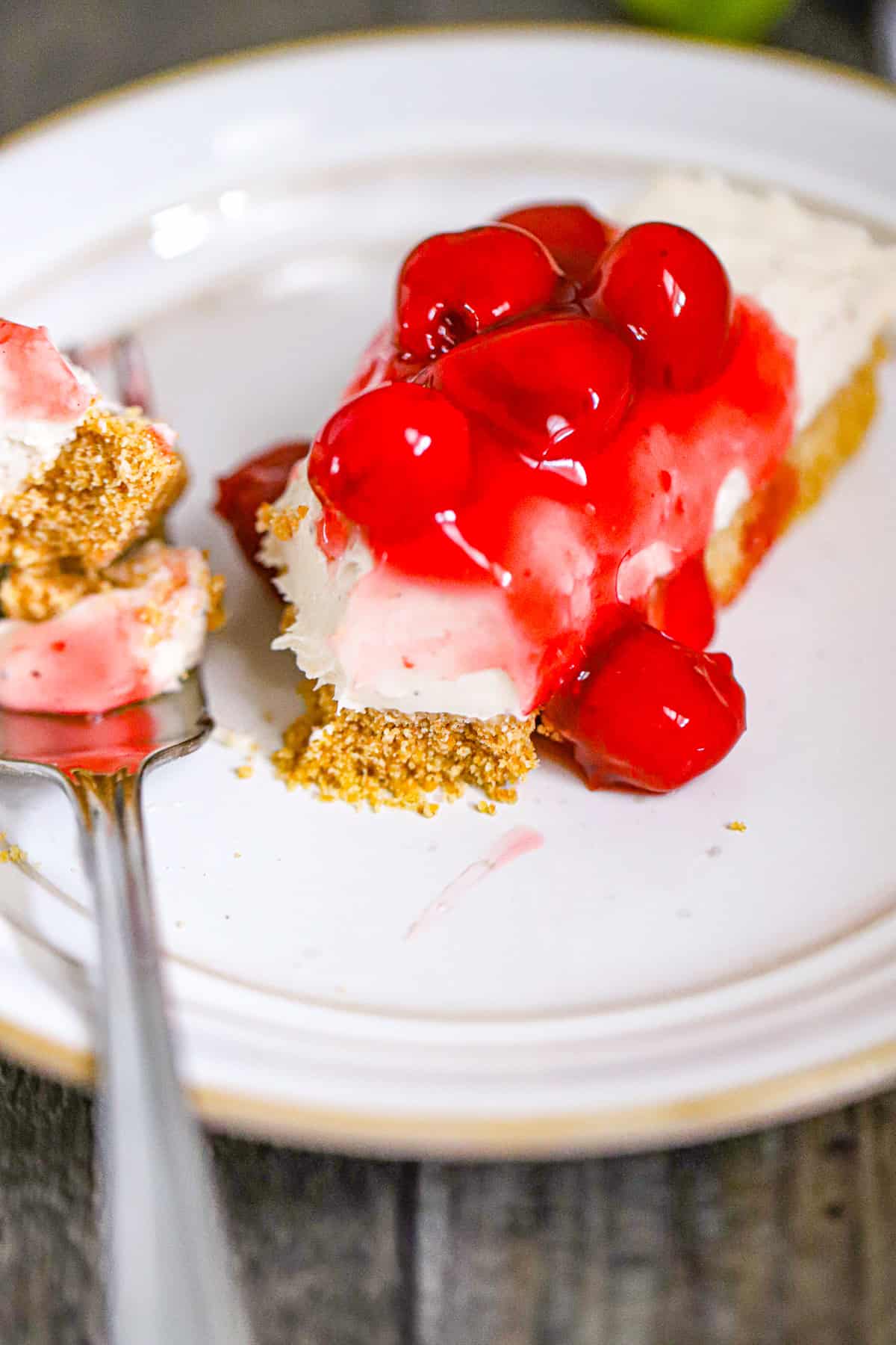 cherry topped cheesecake bar on a white plate