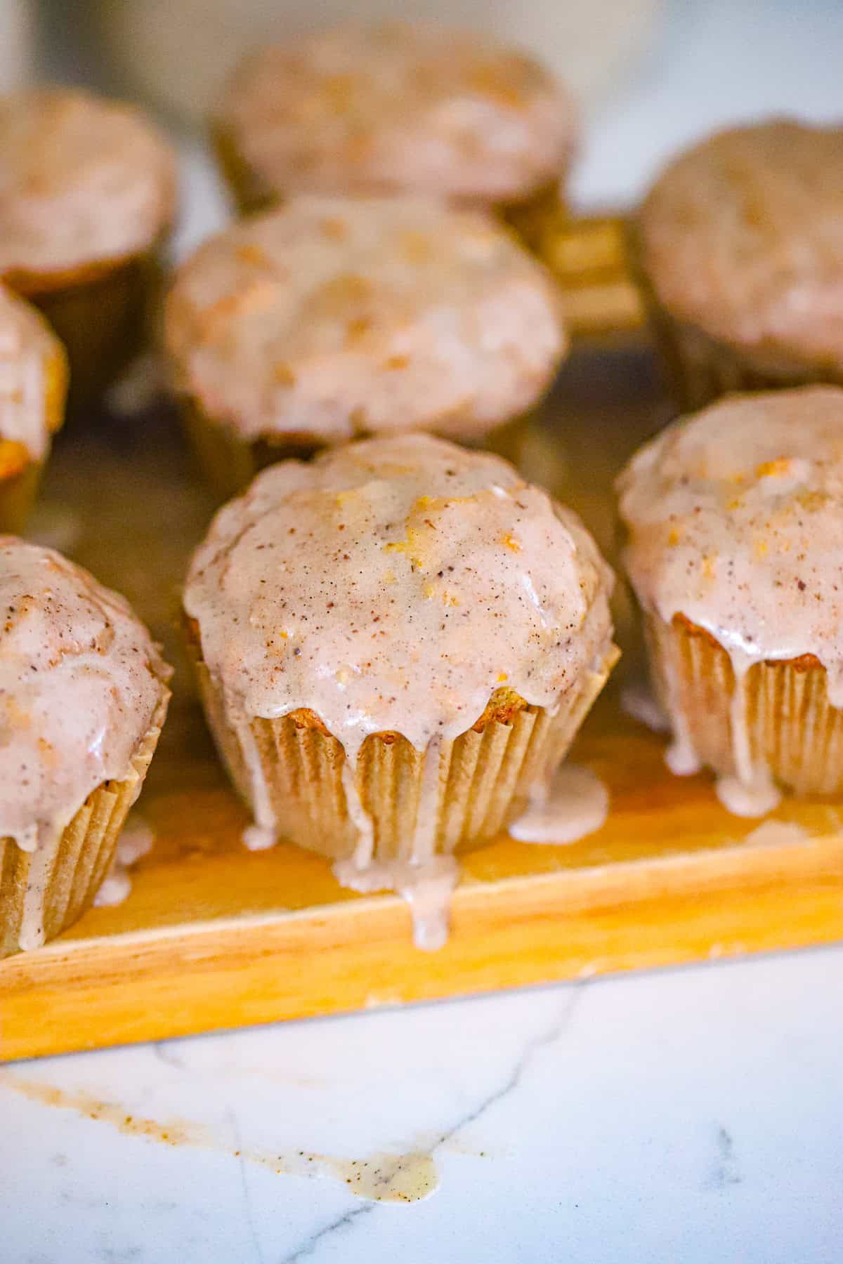 vanilla chai muffins with vanilla bean glaze dripping down the sides
