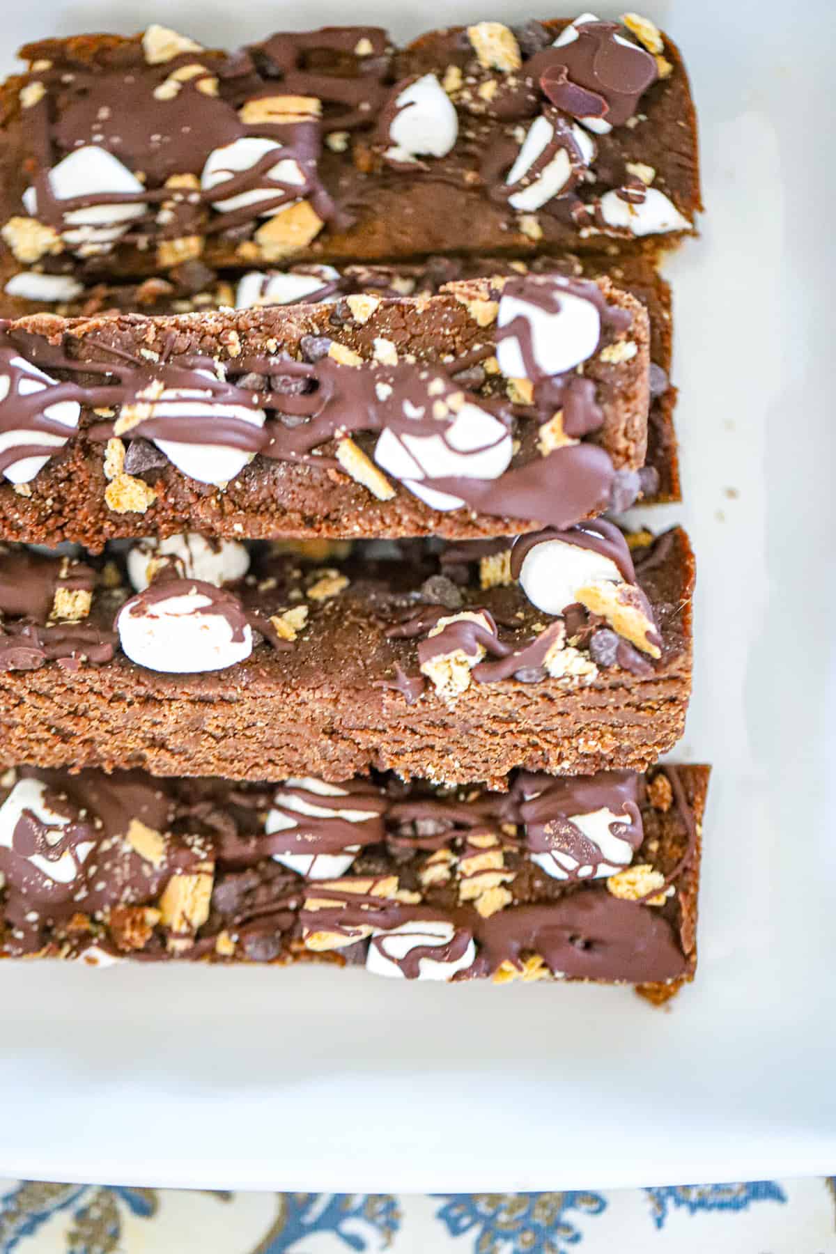 Thick s'mores protein bars sliced showing graham crumbs and gooey marshmallow center