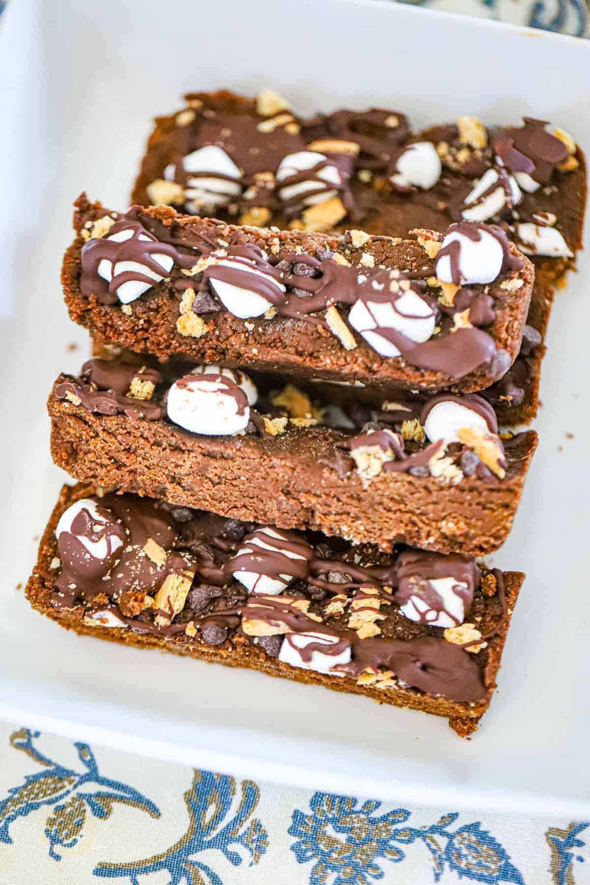 Stacked fudgy chocolate bars with marshmallow topping and graham crumbs