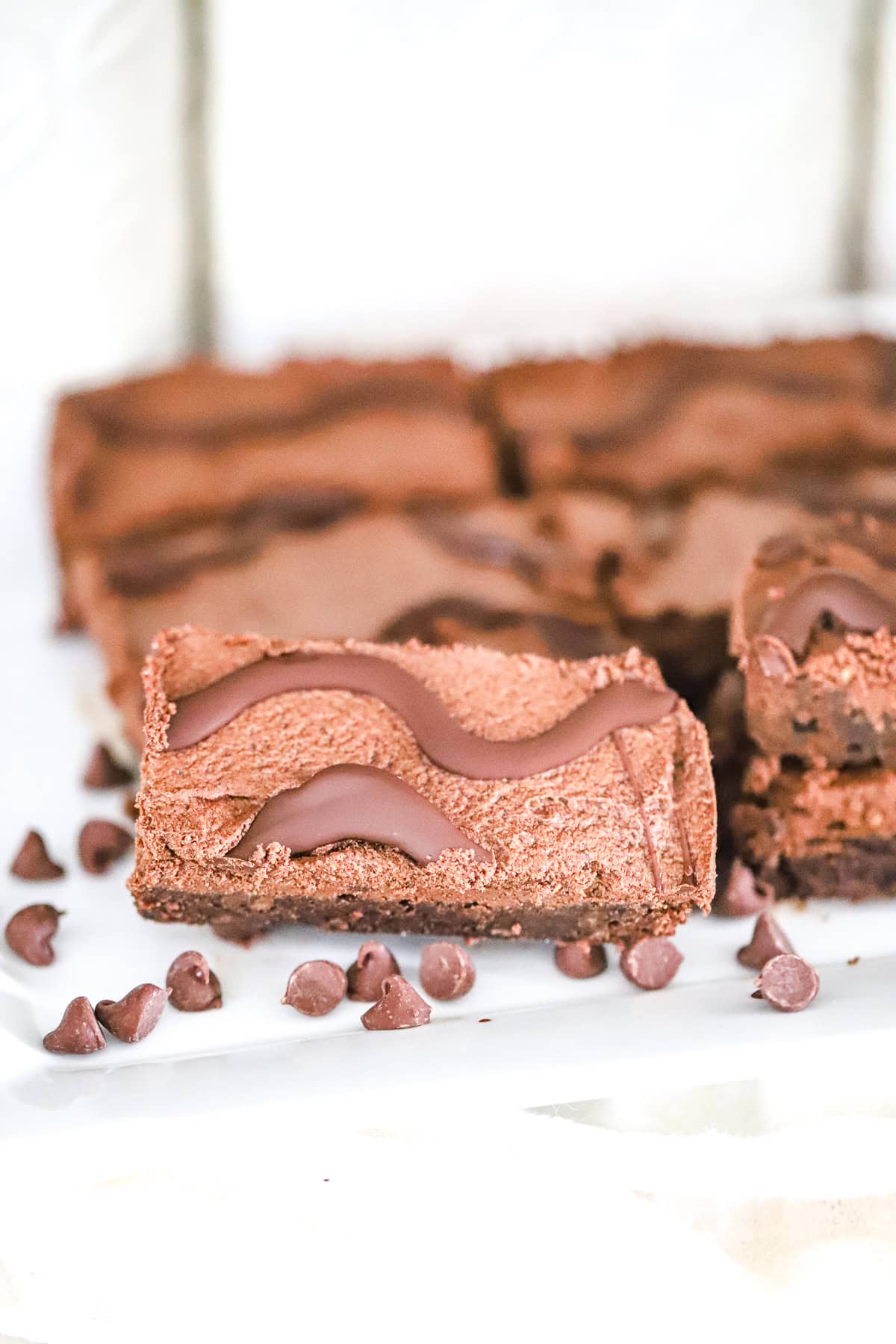 fudge round dessert bars stacked on a plate with chocolate drizzle