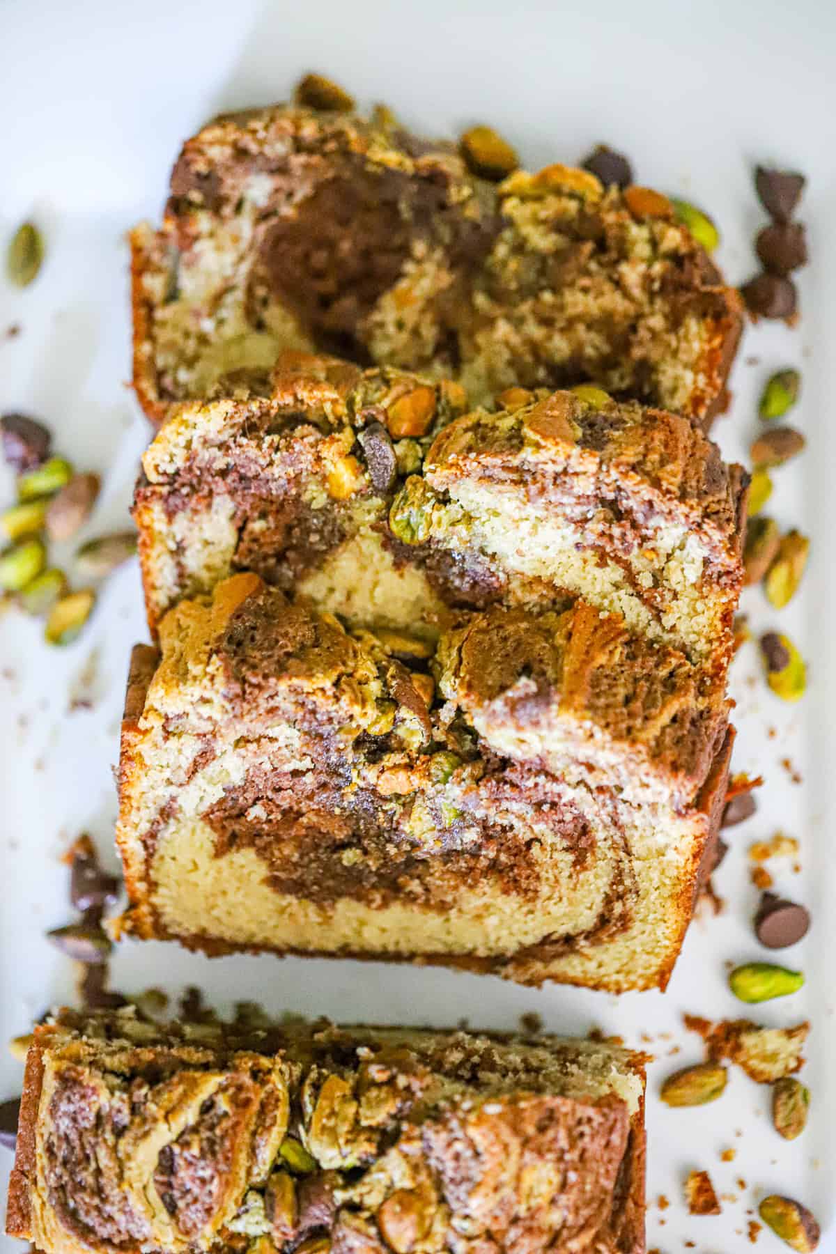 Chocolate pistachio swirl bread loaf topped with chopped pistachios, fresh from the oven