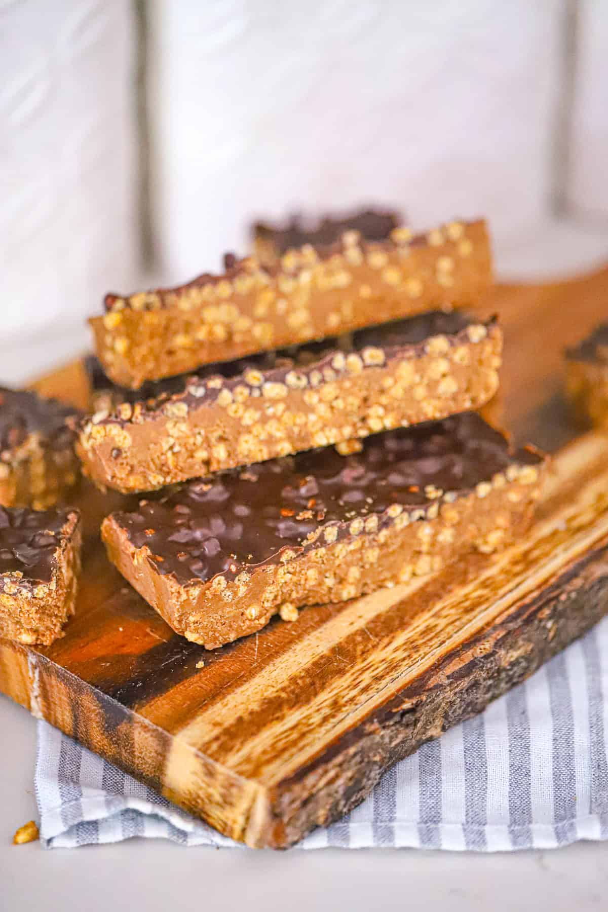 Stack of no bake fudgy bars with a chocolate shell and sea salt on top