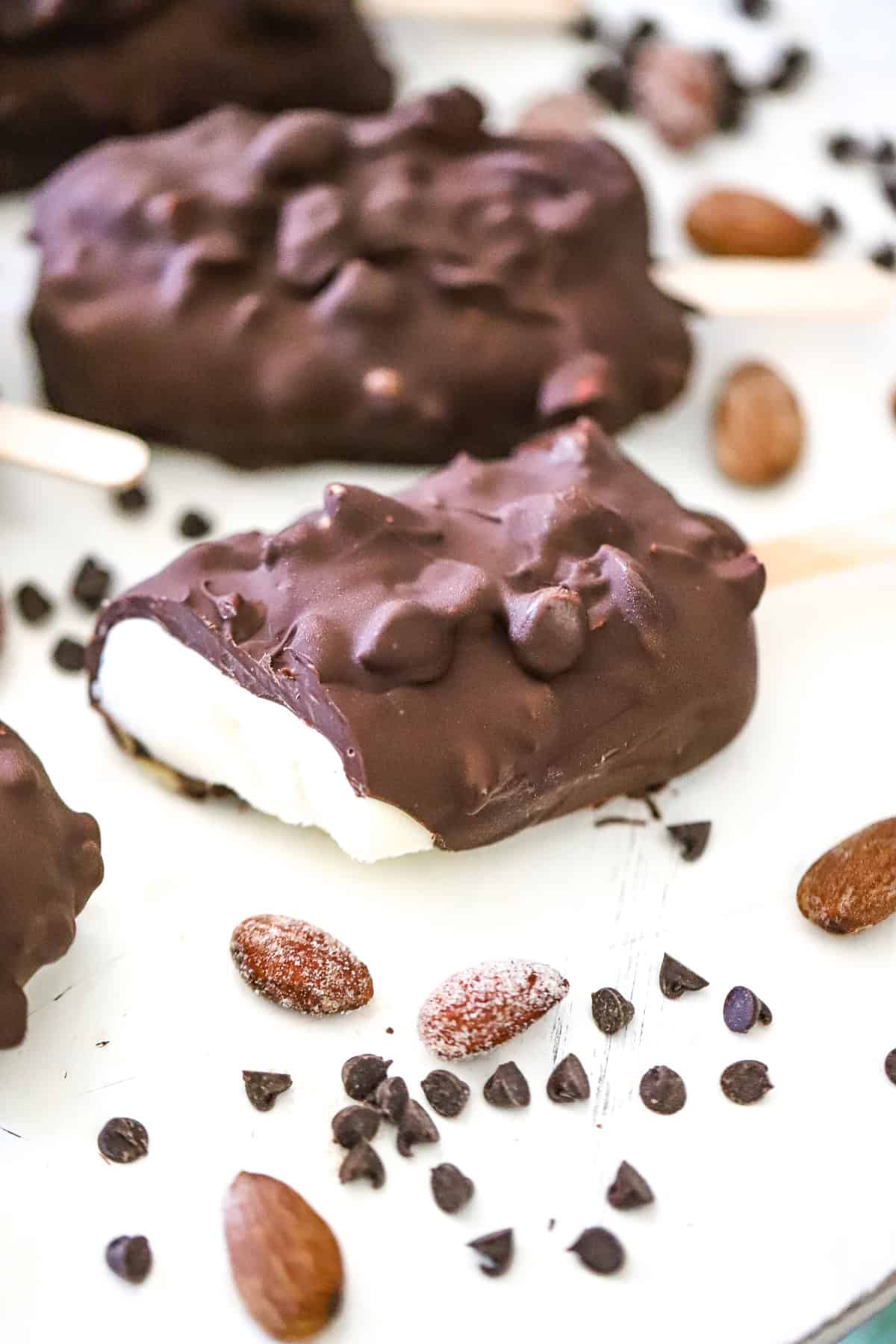 creamy frozen vanilla yogurt bars on a tray with chopped nuts on top
