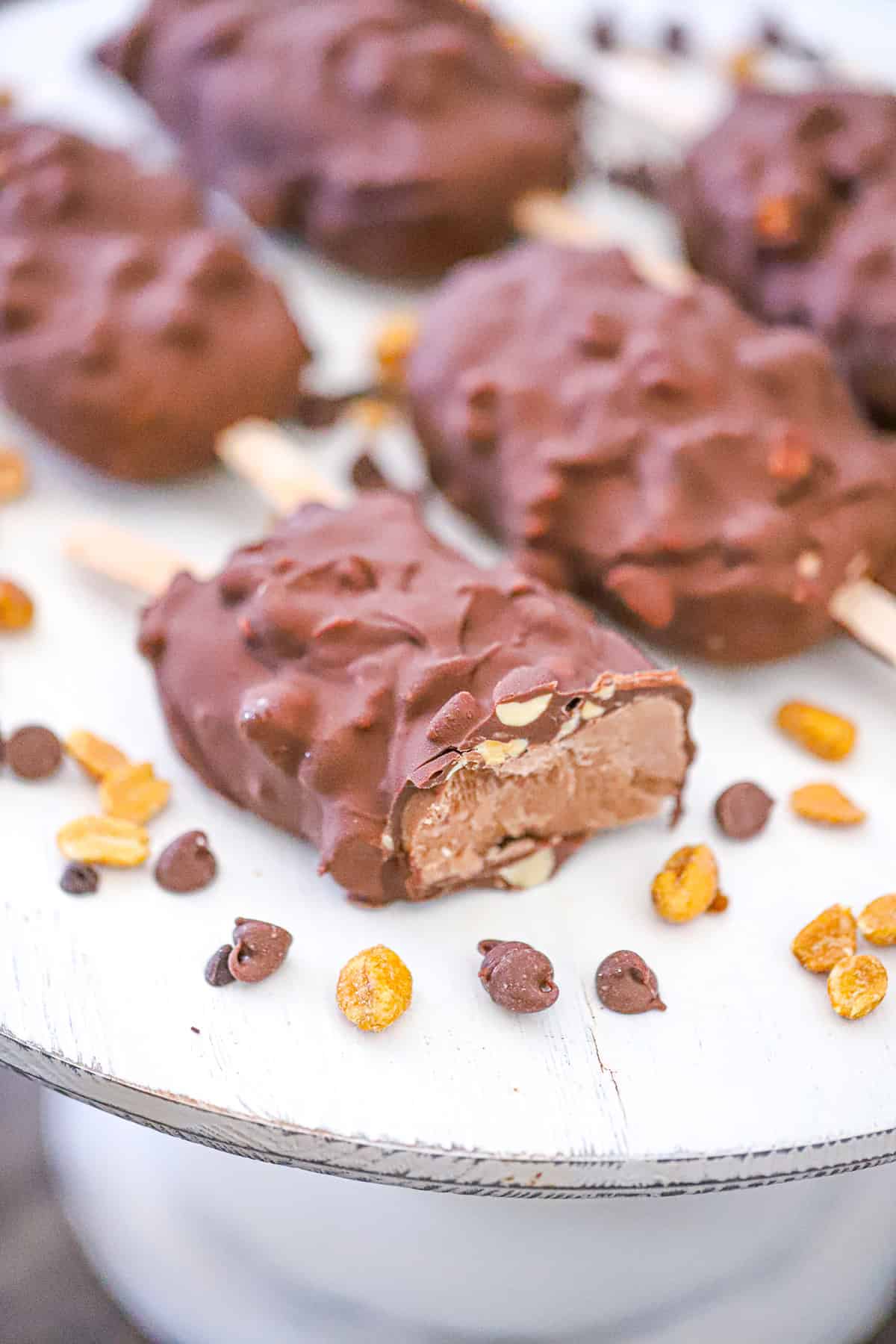 frozen peanut butter bars on sticks with a cracked chocolate coating