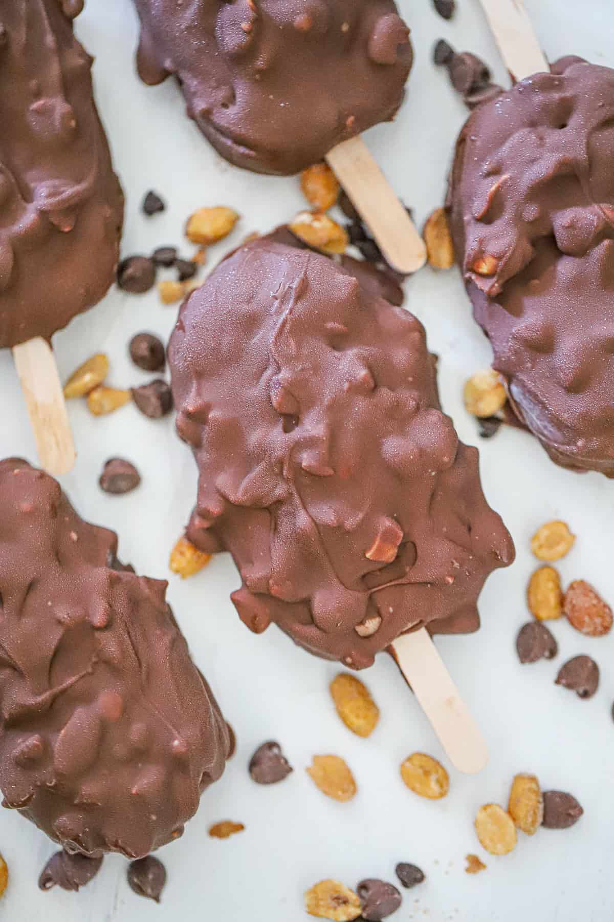 dipping frozen chocolate peanut butter magnum bars into melted chocolate