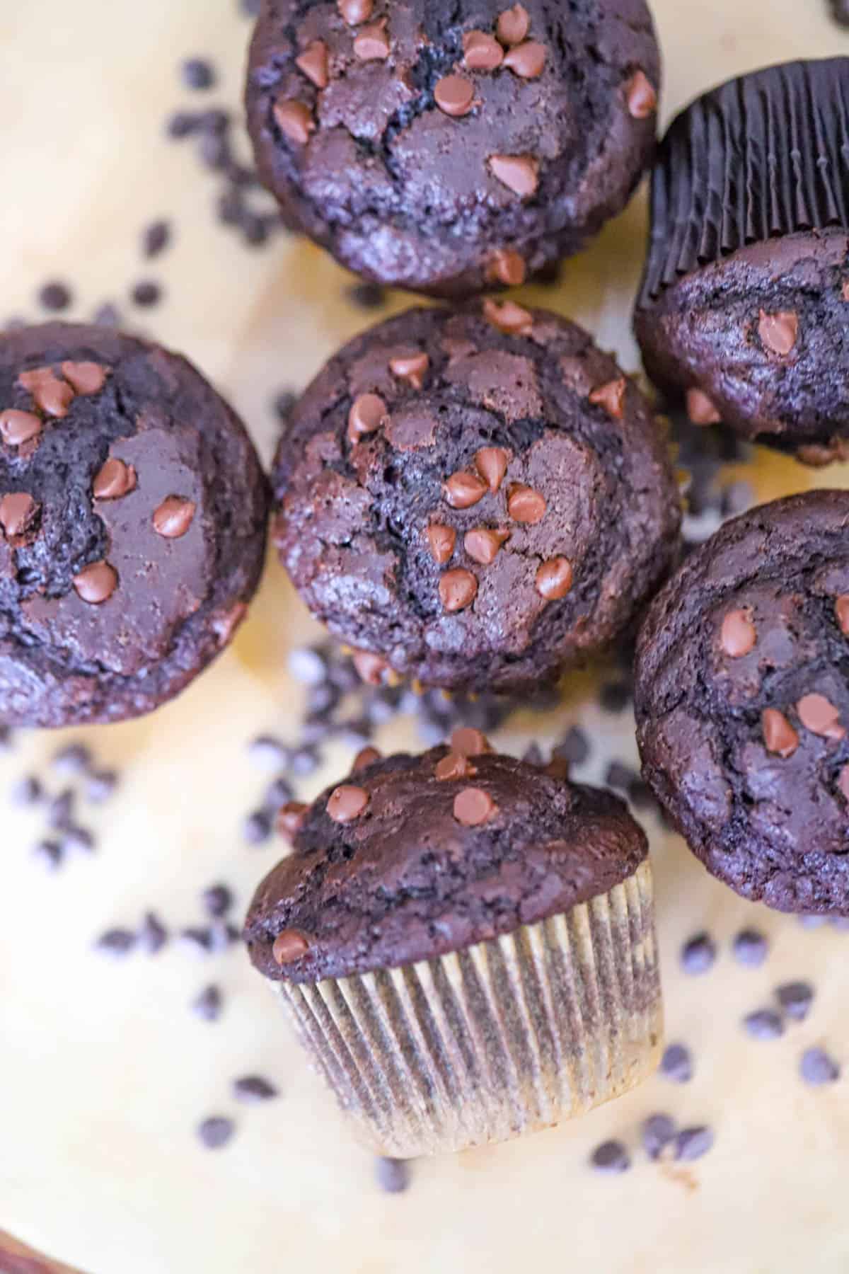 Chocolate chip covered muffin tops beside a warm drink bakery style muffin domes