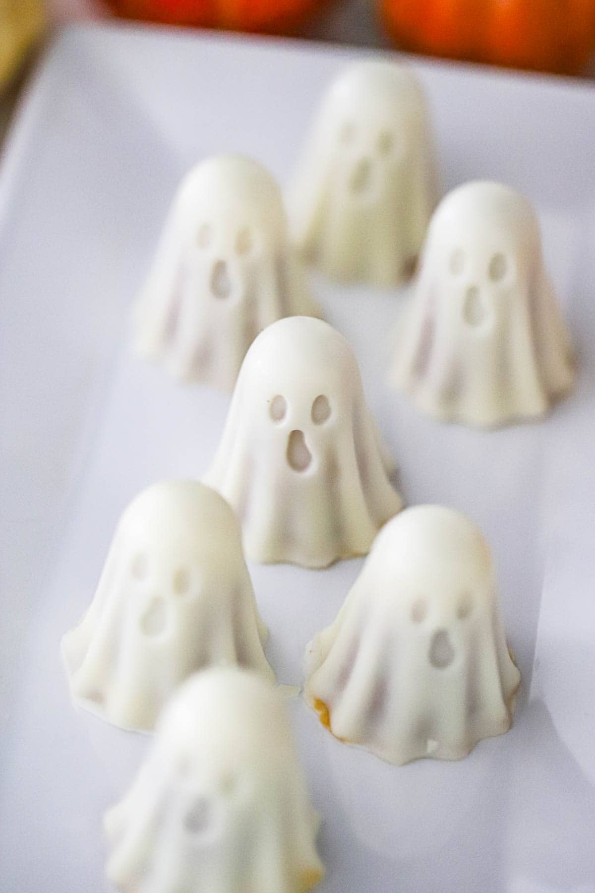 Biscoff peanut butter ghost truffles arranged on a white platter for Halloween