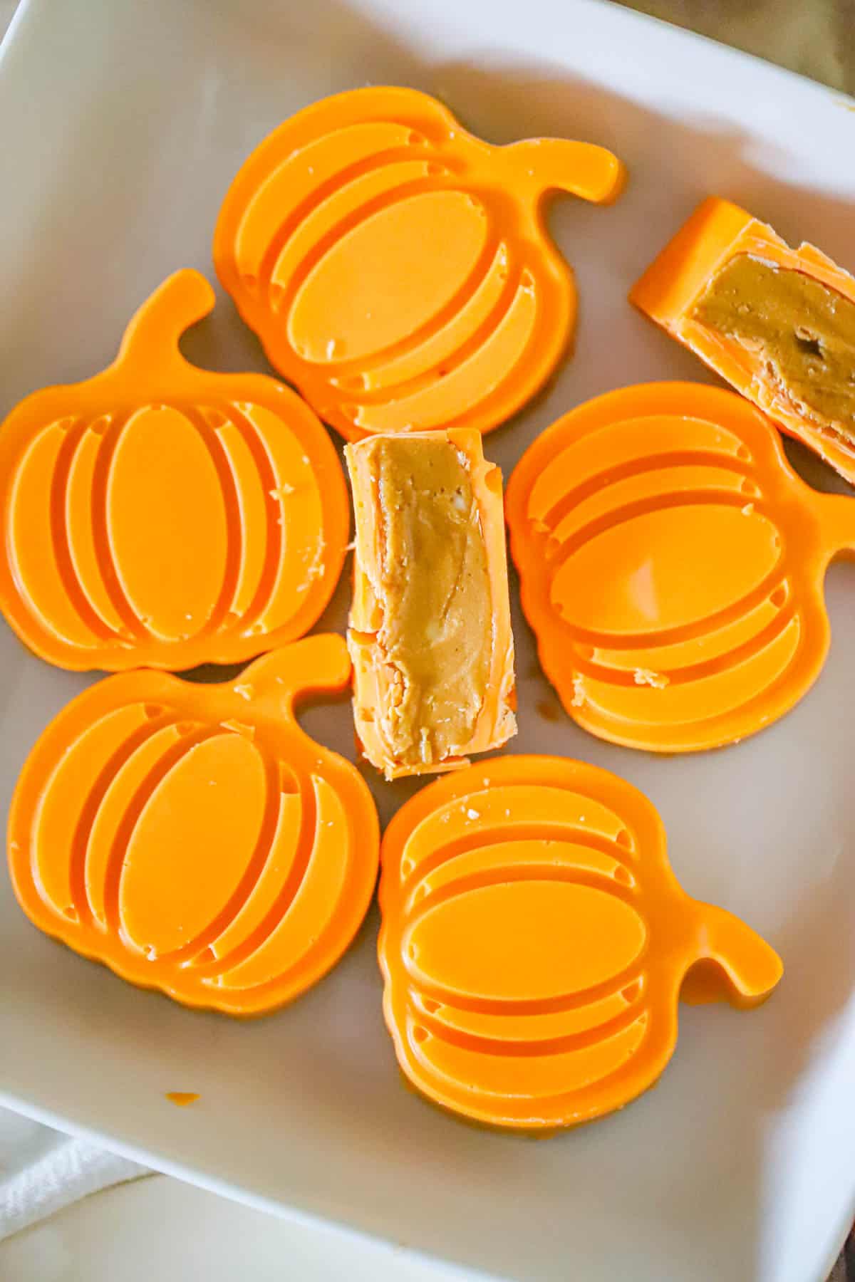 Maple peanut butter cups shaped like orange chocolate pumpkins with one cut open - Fall chocolate treats