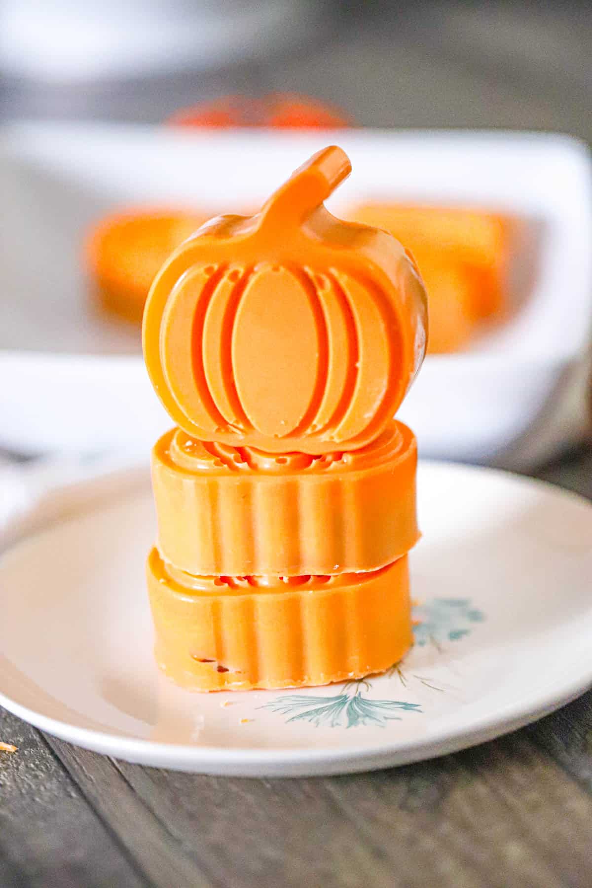 Chocolate pumpkin cups arranged on a white platter with small fall pumpkins - Fall chocolate treats