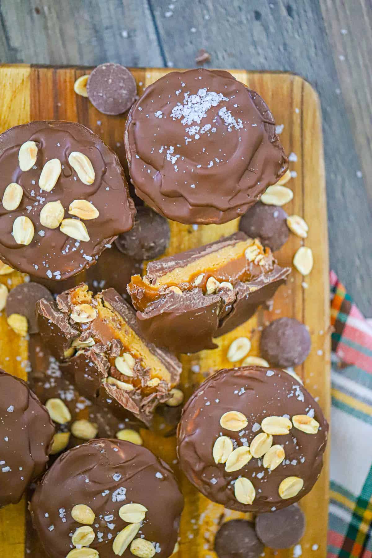 Layered chocolate candy cups with creamy peanut butter gooey caramel and salted peanuts
